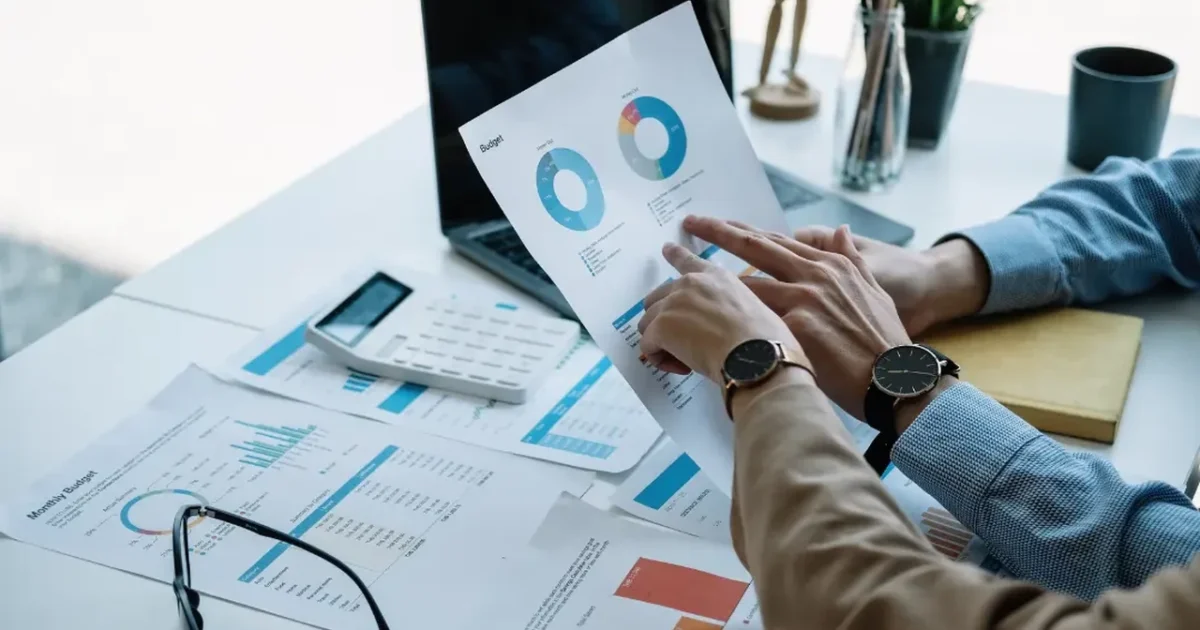 Two people reviewing spend and performance reports at a desk